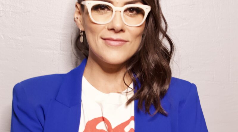 Ana Paulina arms folded standing smiling at camera with fashionable white eyeglasses